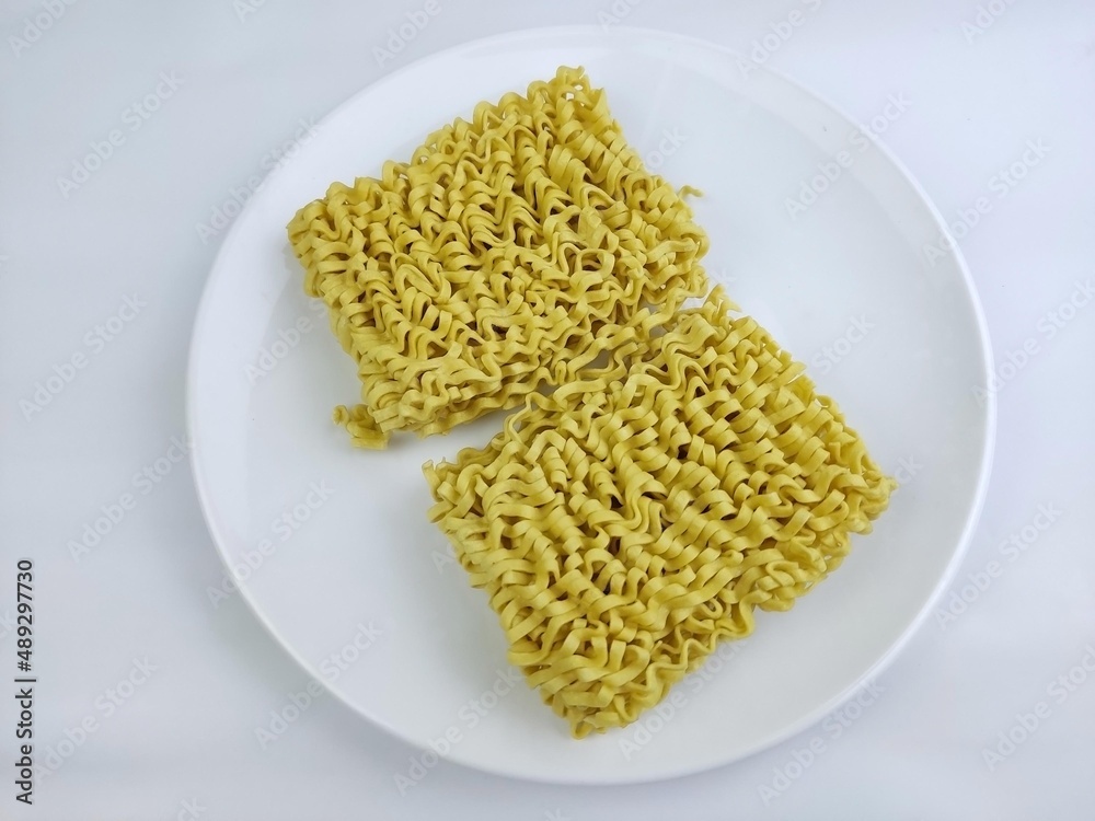 Dry yellow noodles on a white plate on a with background Dry yellow noodles on a white plate on a with background