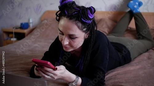 The girl is typing a message on her mobile phone and smiling.