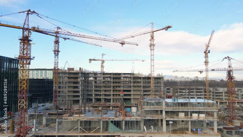 Aerial view towards a large building under construction - approaching, drone shot Aerial view towards a large building under construction - approaching, drone shot
