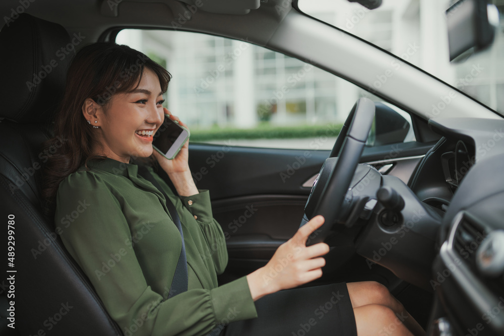 Young woman sitting in the car and calling