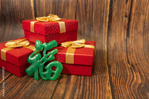 red gift boxes with wooden background, Green Chinese word meaning fortune photo