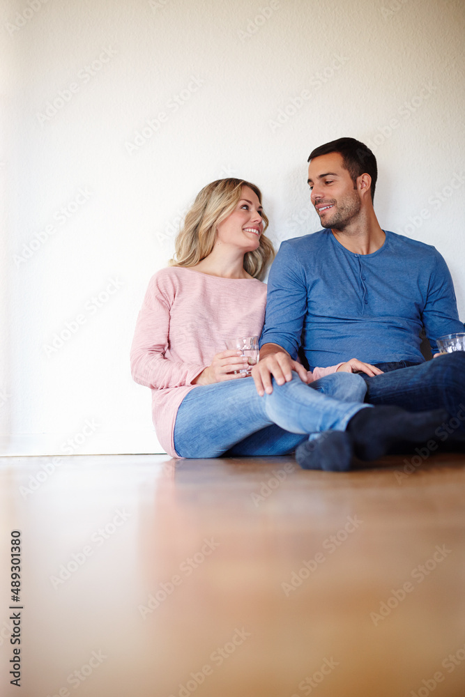 Happy in their new home. Shot of a happy young couple sitting on their living room floor. Happy in their new home. Shot of a happy young couple sitting on their living room floor.