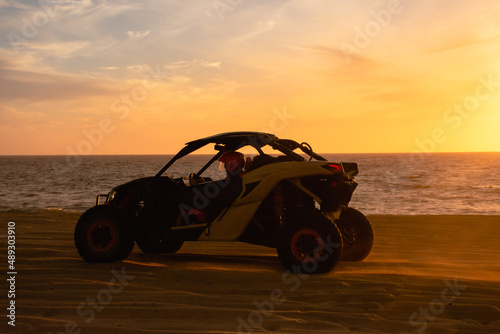 Buggy running on the beach at sunset
