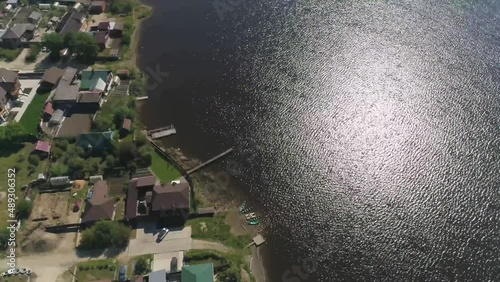 Aerial view of Embankment reconstruction. Nearby is an old factory, a dam, a pond, church. Opens a panorama of a provincial town with one-story houses and trees. Russia, Sysert city
 photo