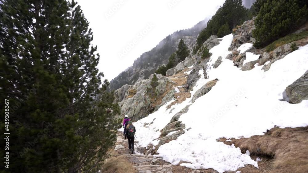 couple of trekkers woman hiking in Rocky Mountain covered with fresh white snow, explore adventure remote protected area, gimbal shot couple of trekkers woman hiking in Rocky Mountain covered with fresh white snow, explore adventure remote protected area, gimbal shot
