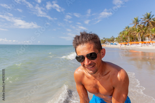 athletic, tanned man with a naked torso on a Caribbean beach