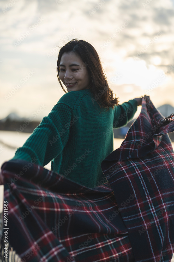 Obraz premium 夕暮れの河川敷にいる女性