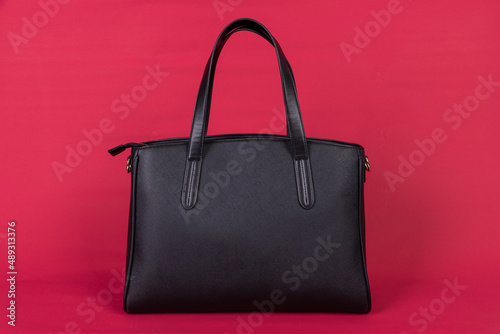 A black leather bag on a red background