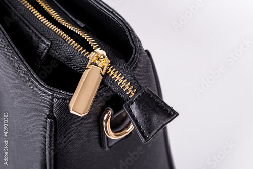 The details and workmanship of a black leather bag are on a white background