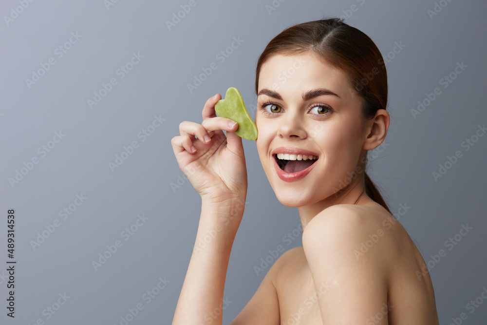 woman face scraper wrinkle smoothing bare shoulders close-up Lifestyle woman face scraper wrinkle smoothing bare shoulders close-up Lifestyle