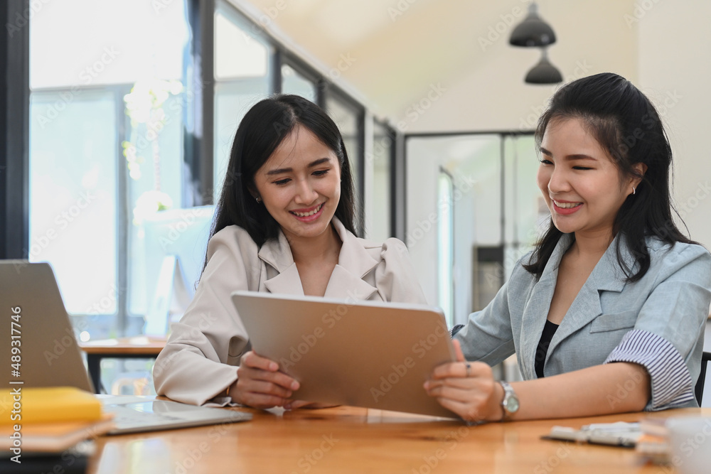 Friendly manager mentor giving instructions and showing new online project on digital tablet to intern employee. Friendly manager mentor giving instructions and showing new online project on digital tablet to intern employee.