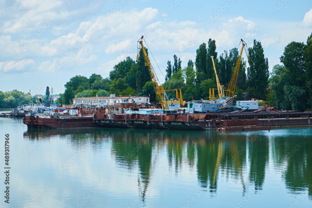 Naklejka premium A small industrial river port in the city. A river for small navigation.