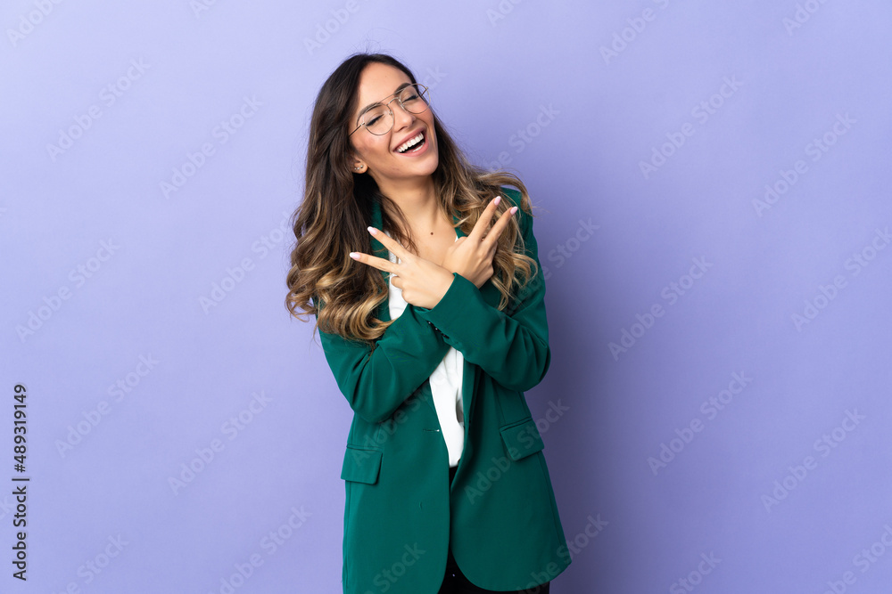 Young caucasian woman isolated on purple background smiling and showing victory sign Young caucasian woman isolated on purple background smiling and showing victory sign