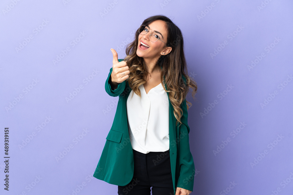 Young caucasian woman isolated on purple background with thumbs up because something good has happened Young caucasian woman isolated on purple background with thumbs up because something good has happened