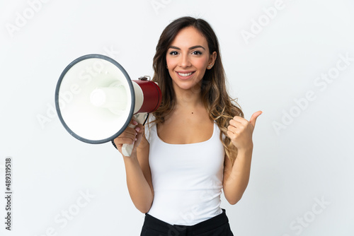 Young caucasian woman isolated on white background holding a megaphone with thumb up
