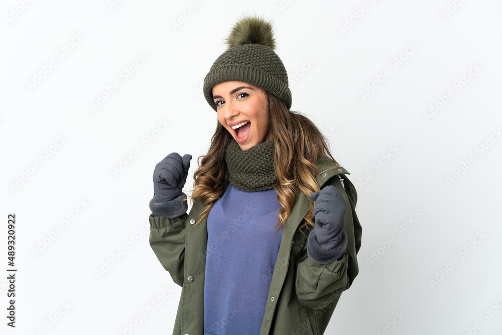 Young girl with winter hat isolated on white background celebrating a victory in winner position Young girl with winter hat isolated on white background celebrating a victory in winner position