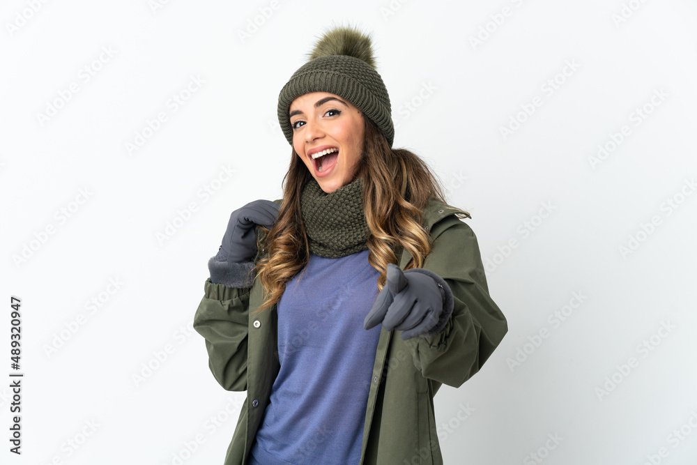 Young girl with winter hat isolated on white background surprised and pointing front Young girl with winter hat isolated on white background surprised and pointing front