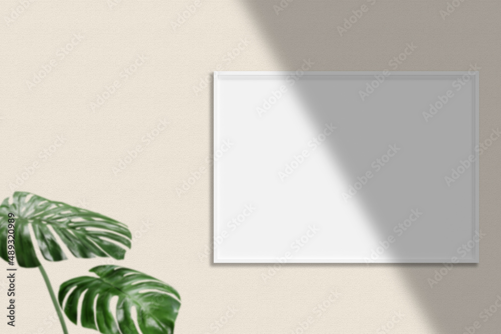 Minimalist hanging horizontal white poster or photo frame mockup in living room wall with plant. Minimalist hanging horizontal white poster or photo frame mockup in living room wall with plant.