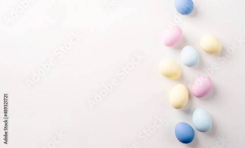 Pastel colored easter eggs on white background with copy space