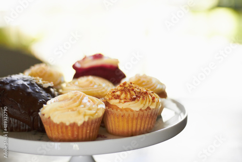 Lifes little sweet pleasures. A tray of an assortment of delicious cupcakes with creamy frosting.