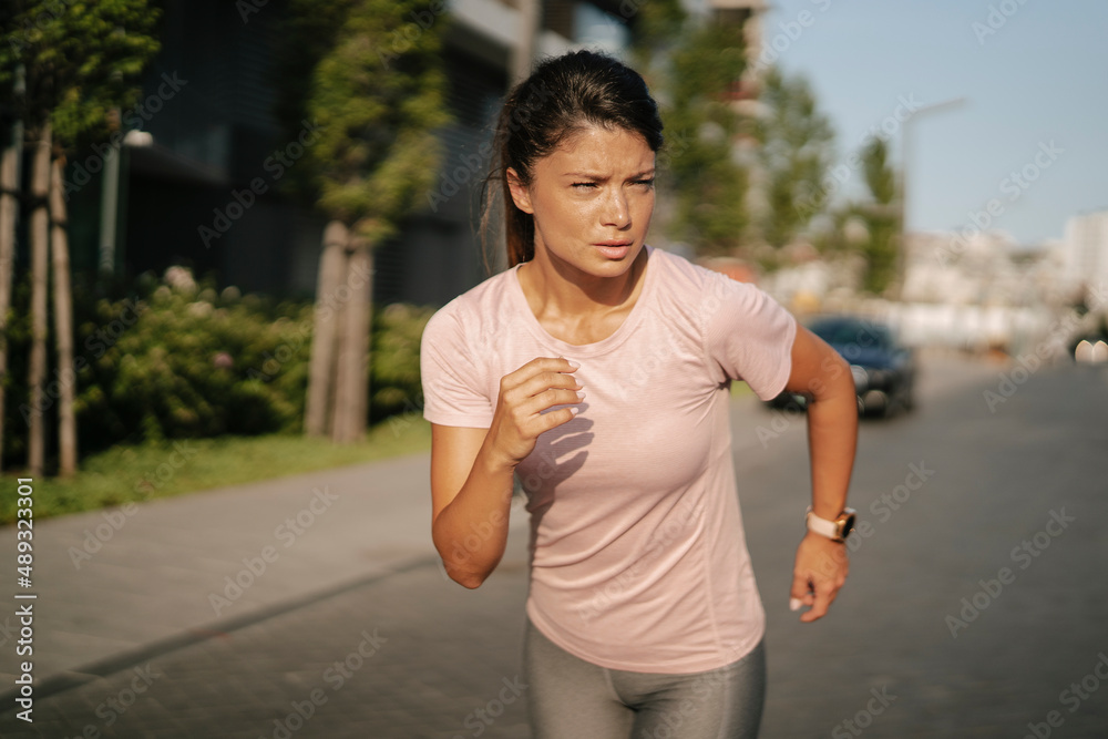 Fit athlete woman in sportswear outdoors. Young woman jogging outside.. Fit athlete woman in sportswear outdoors. Young woman jogging outside..