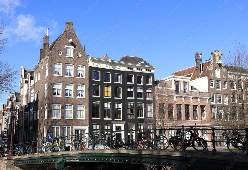 Amsterdam Singel Canal Street View with Corsgenbrug Bridge, Parked Bicyces and Buildings, Netherlands