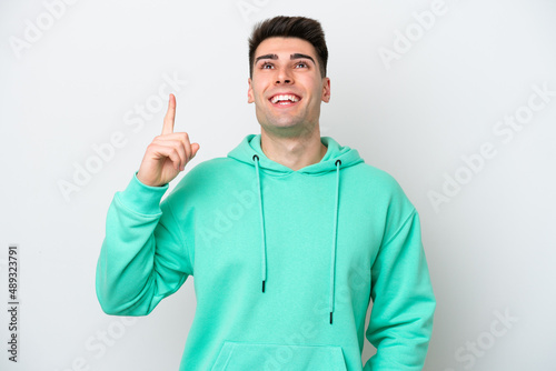 Young caucasian man isolated on white background pointing up and surprised © luismolinero