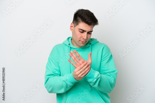 Young caucasian man isolated on white background suffering from pain in hands