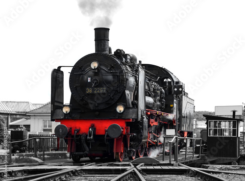 Steam Locomotive “Br 38“ on a historic turntable in Ruhr Basin Germany, ready to leave the depot with historic coaches of “Ruhrtalbahn“ in Ruhr valley. Black and white greyscale with colored elements.