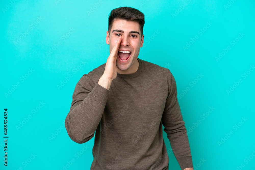 Young caucasian man isolated on blue background shouting with mouth wide open Young caucasian man isolated on blue background shouting with mouth wide open