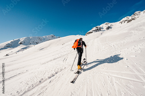 Ziarska dolina, slovakia, 10.2.2022. Mountaineer backcountry ski walking ski alpinist in the mountains. Ski touring in alpine landscape with snowy trees. Adventure winter sport. photo