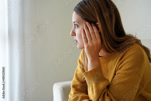 Quadro em tela Portrait of sad lonely girl at home looking through window