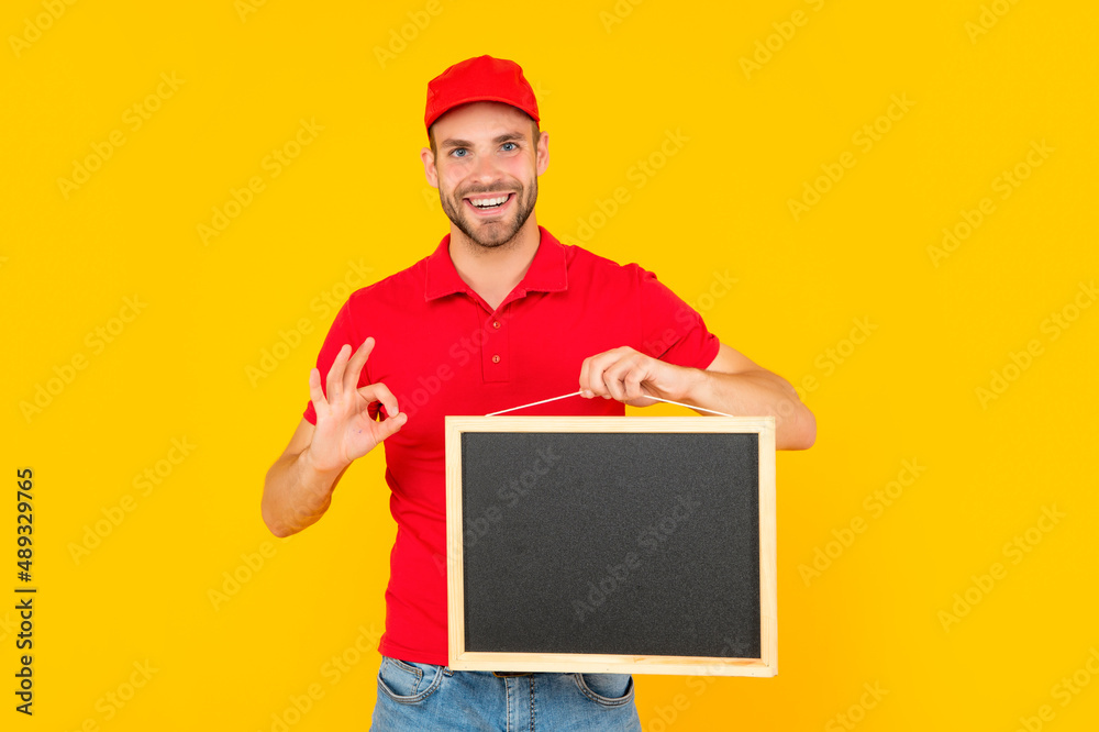 unshaven young man in red shirt hold blackboard with copy space on yellow background, advertisement unshaven young man in red shirt hold blackboard with copy space on yellow background, advertisement