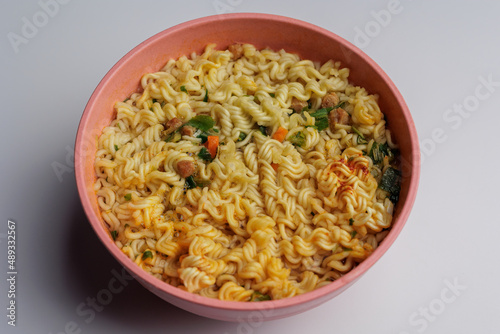 Instant noodles in a white plate top view. Fast food for lunch.