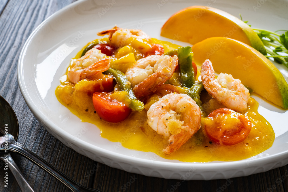 Prawns in mango sauce on wooden table
Prawns in mango sauce on wooden table