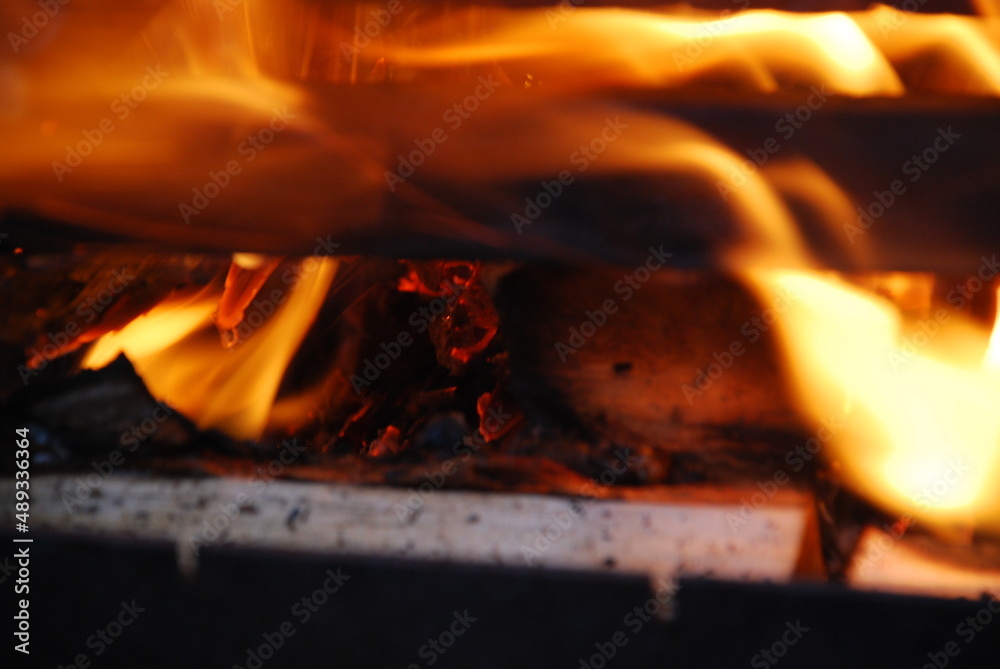 The fire blazes between the firewood stacked durgas on top of each other. Several pine and birch logs are stacked in a square tower in the center of which sawdust and wood chips burn brightly.