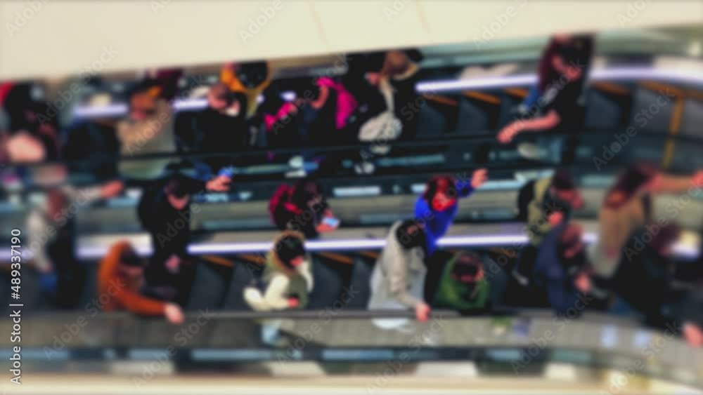 custom made wallpaper toronto digitalUnrecognizable unfocused shoppers ride escalators inside the mall. The light flashes on the escalator steps.