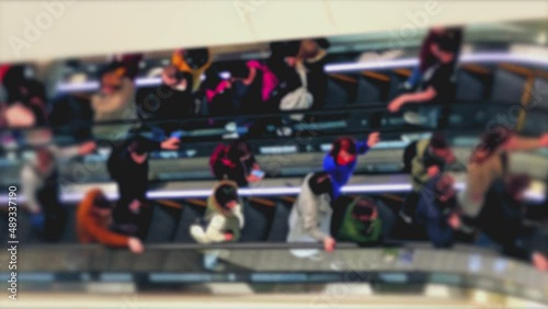 Wallpaper Mural Unrecognizable unfocused shoppers ride escalators inside the mall. The light flashes on the escalator steps. Torontodigital.ca