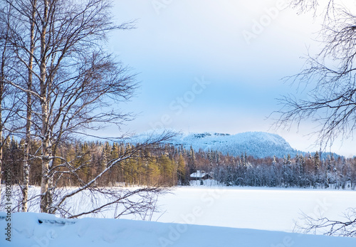 Snowy plain, frozen lake and winter landscape. Sunrise over the mountain. © Fox
