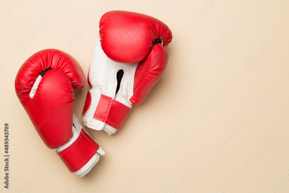 Pair of red boxing gloves on color background. Top view