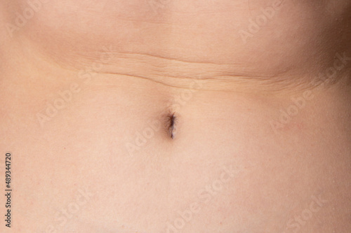 Woman belly with folds. Parts of a female body. Perfect body shape.