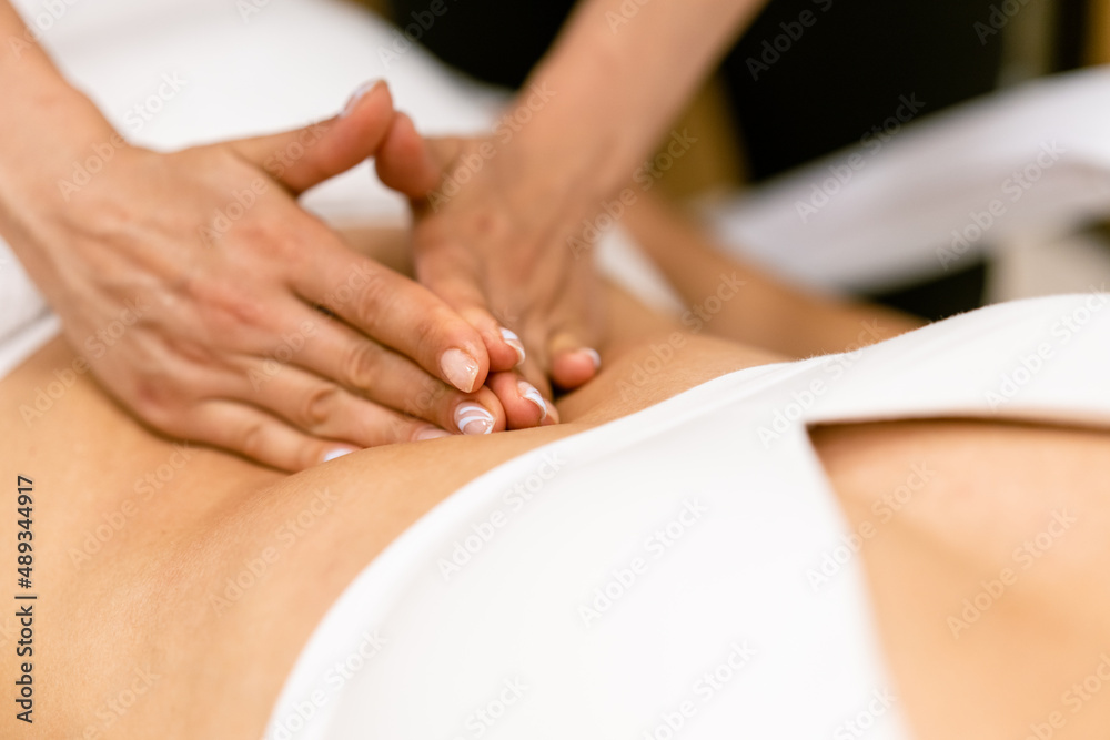 Middle-aged woman having a belly massage in a beauty salon. Middle-aged woman having a belly massage in a beauty salon.