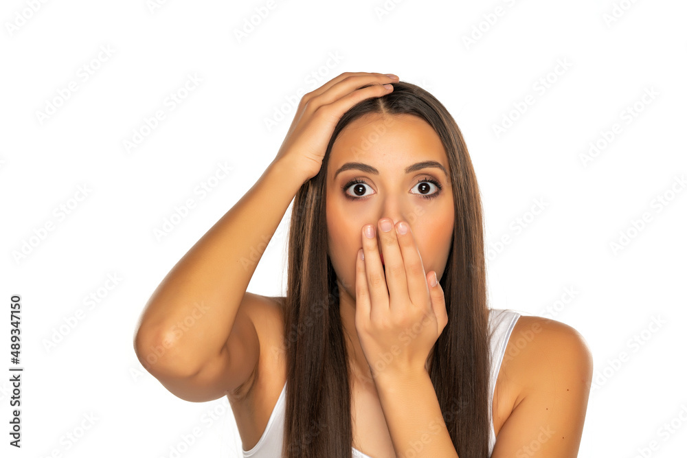 Shocked young woman covers her mouth with her hand Shocked young woman covers her mouth with her hand