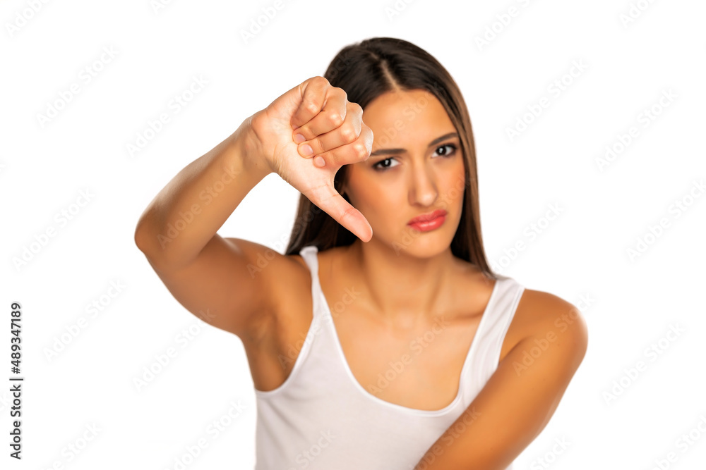Angry woman doing dislike thumb down gesture Angry woman doing dislike thumb down gesture