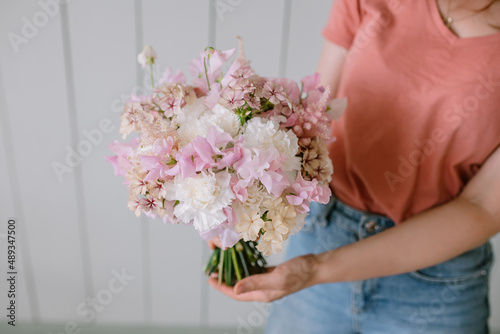 Beautiful bouquet of fresh flowers in female hands. Florist holding plants