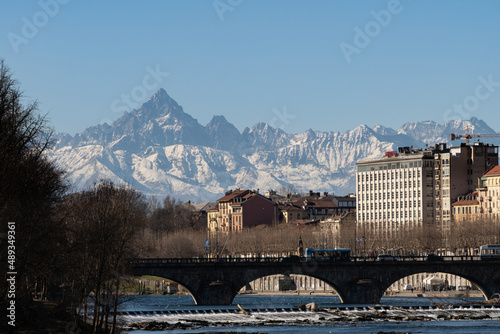 View of the Alps from the city of Torino. Next to the Po' River. Old buildings and Monviso in the background.