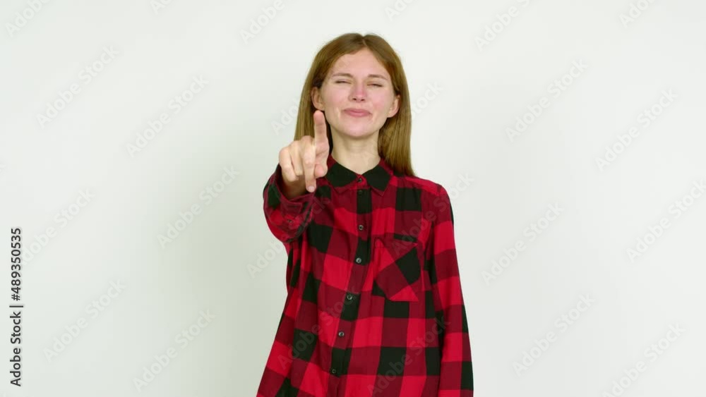 Young woman points finger at you with a confident expression over isolated background Young woman points finger at you with a confident expression over isolated background
