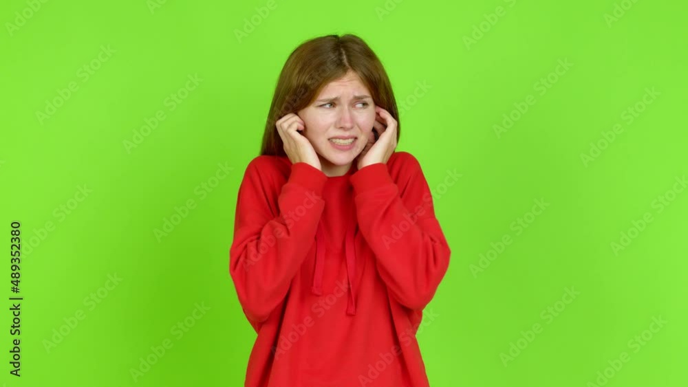 Young woman covering both ears with hands. Frustrated expression over isolated background. Green screen chroma key Young woman covering both ears with hands. Frustrated expression over isolated background. Green screen chroma key