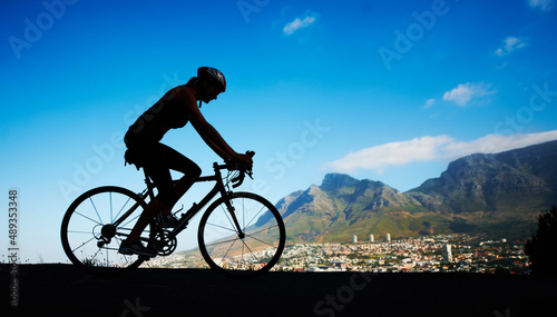 No view better. Silhouette shot of a young woman cycling against a beautiful scenic view.