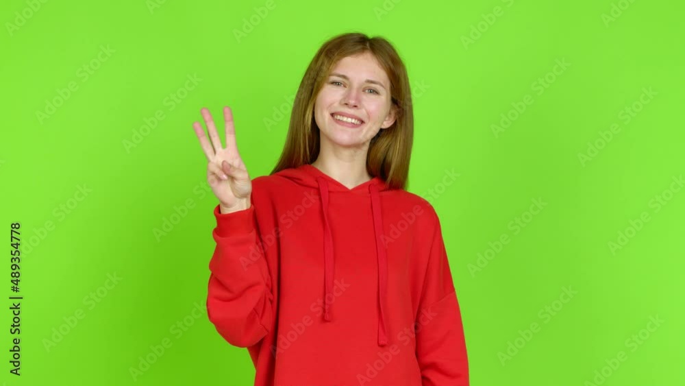 Young woman happy and counting with fingers over isolated background. Green screen chroma key